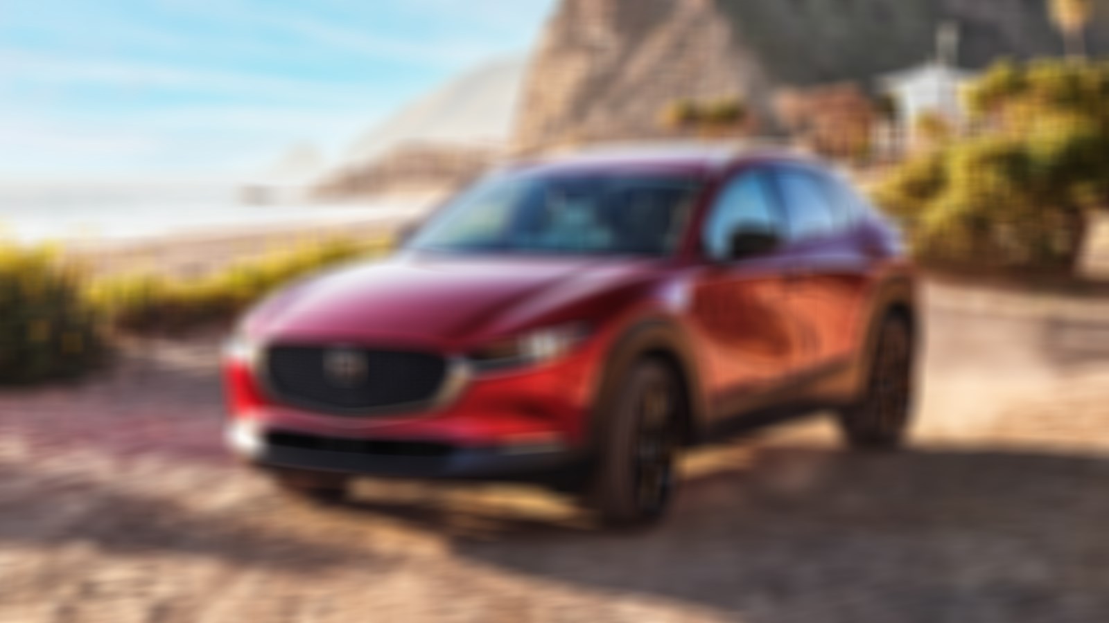 Soul Red Crystal Metallic Mazda CX-30 parked at beach during golden hour. 