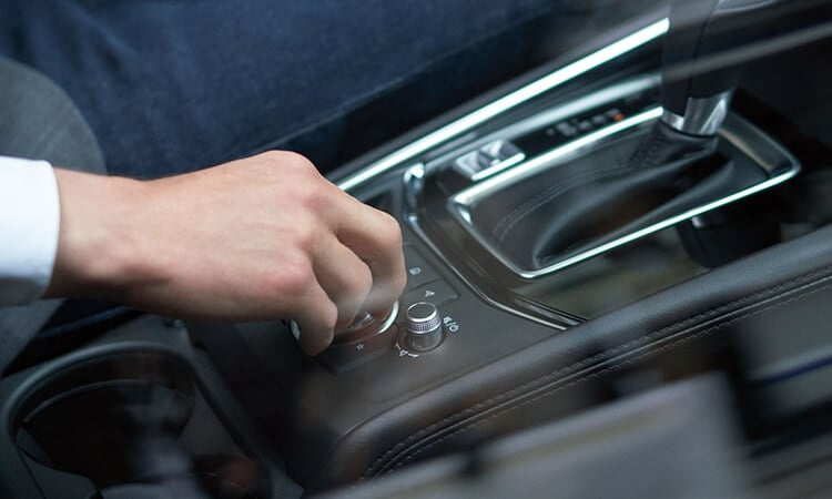 La main droite du conducteur qui ajuste le bouton du poste de contrôle HMI. 