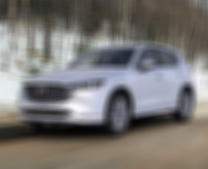 Un CX-5 blanc rhodium métallisé sur une route de campagne hivernale.  