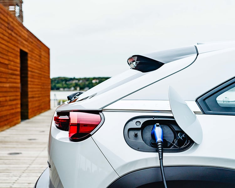 Close up of plugged-in MX-30 EV charging port near the right taillight.