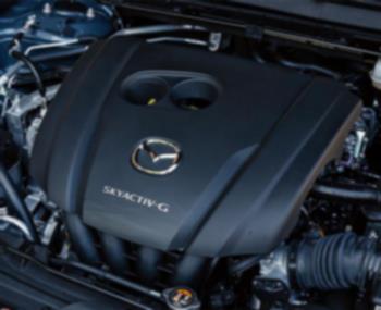 À l’intérieur du capot du CX-30, un couvercle de moteur avec le logo Mazda et l’insigne Skyactiv-G. 