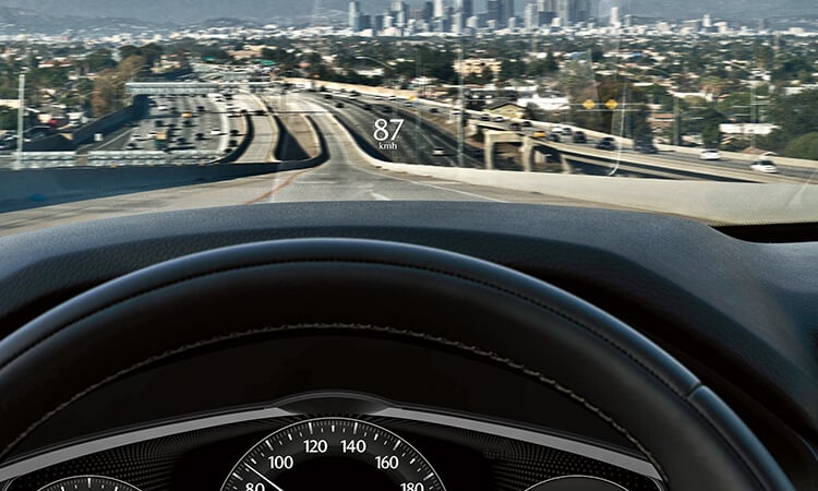 Heads up display reads “87km/h” projected on windshield.