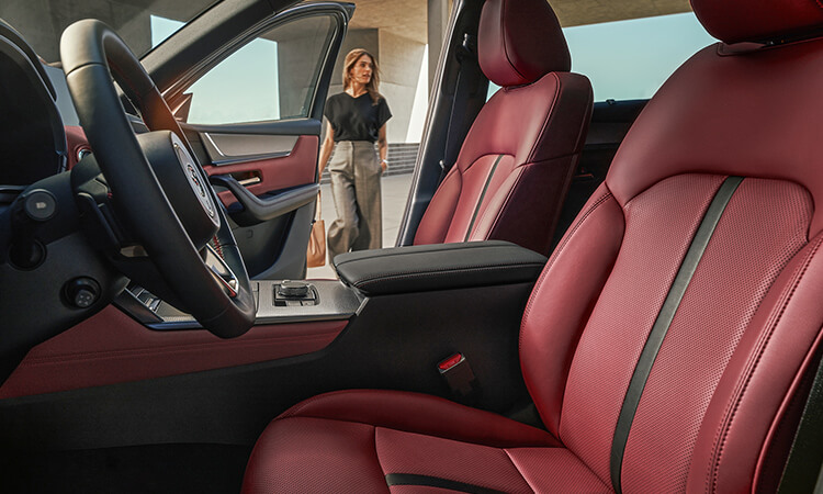 Shot from the driver’s seat looking out toward the open passenger’s side door at women approaching the CX-70.