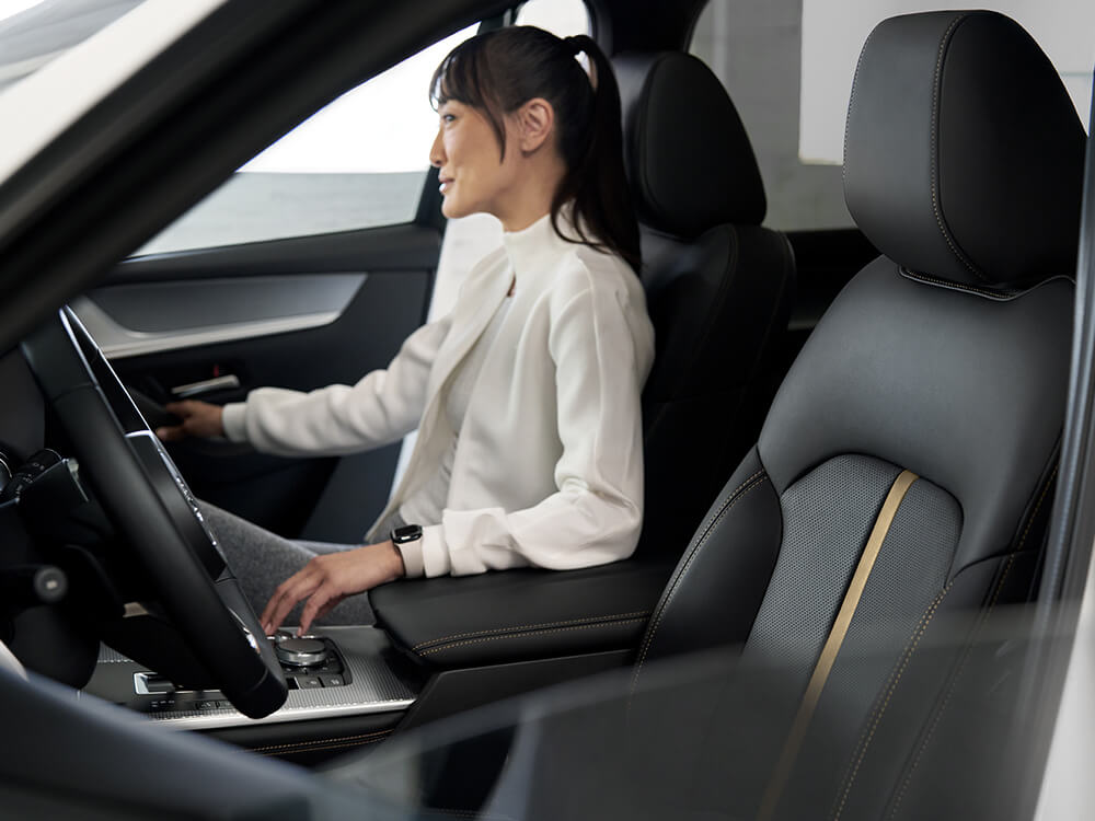 Shot from driver’s side window of parked CX-70, a smiling passenger opens the door.